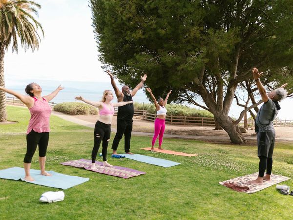 Group of diverse athletes stretching on yoga mats.
